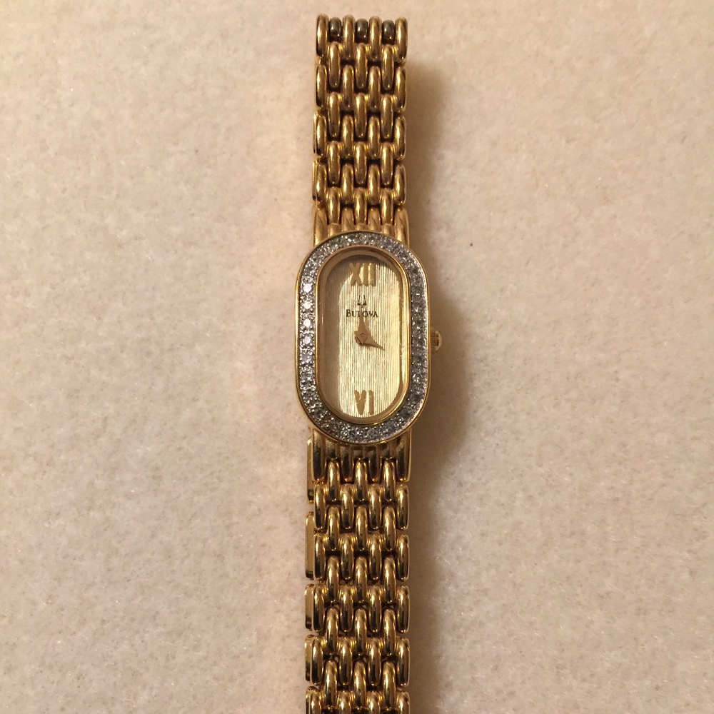 Bulova Women Gold Watch with Crystal stones going around face of the watch.